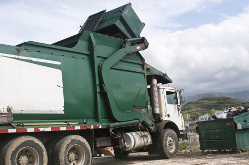 Company van and staff preparing commercial waste containers outside a Lee business